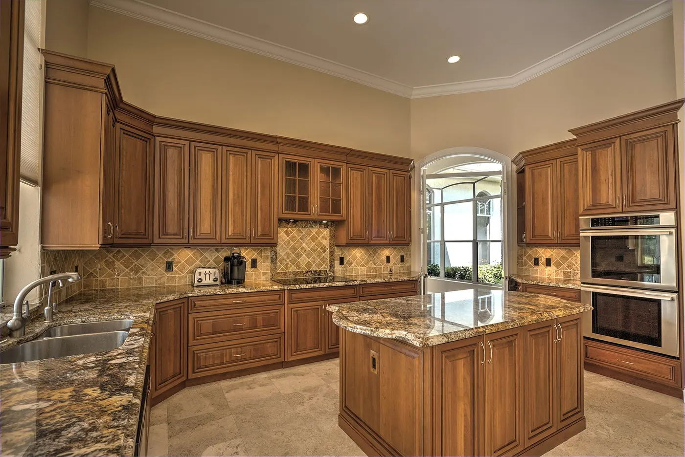 A kitchen with white crown molding along the ceiling and cabinet tops