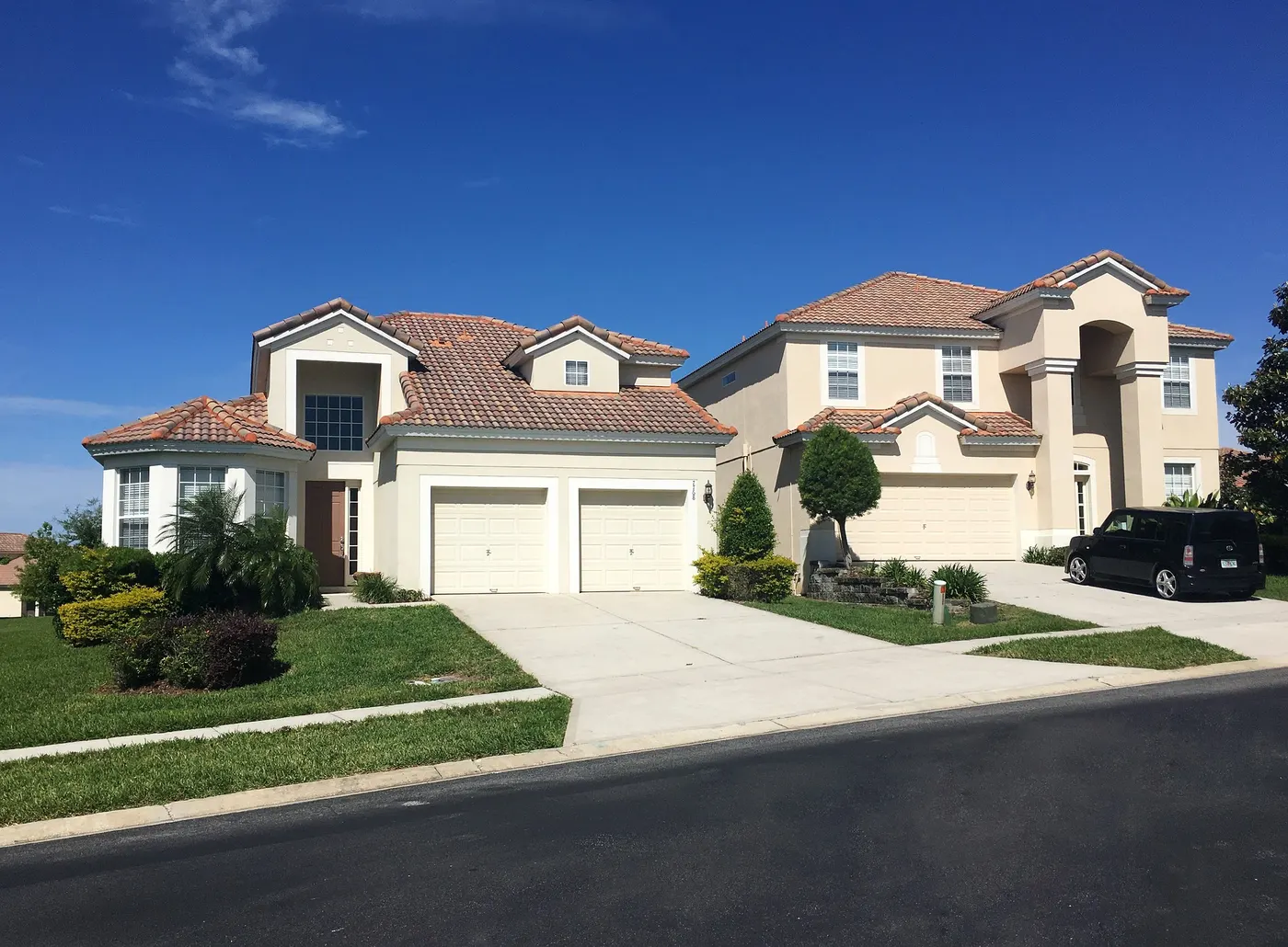 Suburban homes with white double garage doors and driveways
