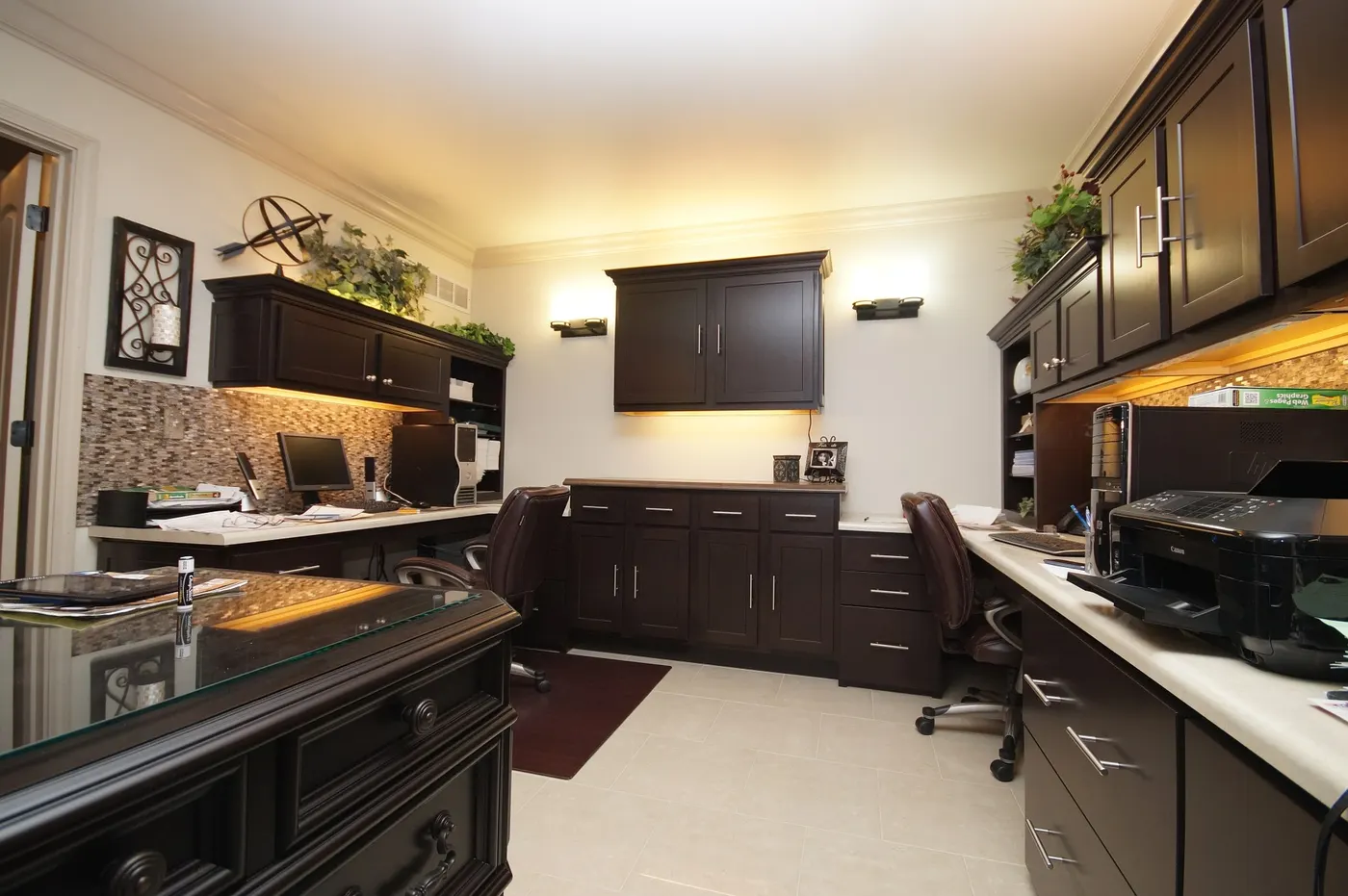 A remodeled home office with built-in cabinets and a tiled backsplash