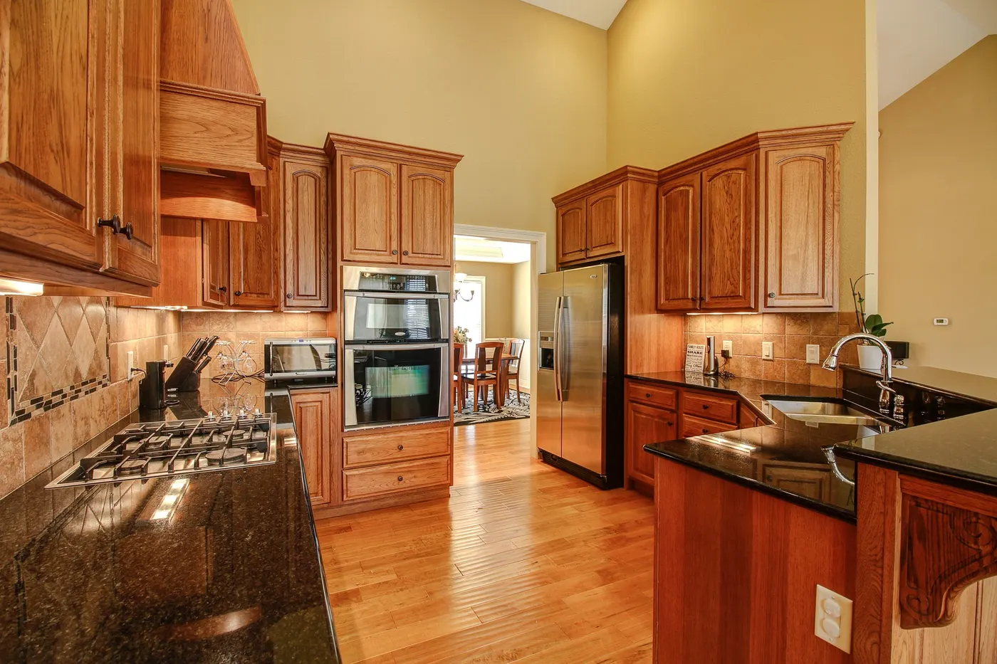 A remodeled kitchen with wood cabinets, granite counters and stainless appliances